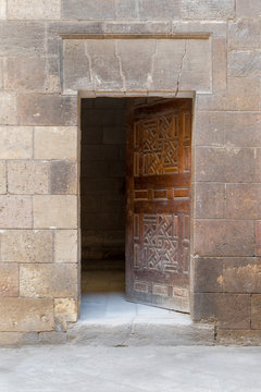 Wooden grunge old door and stone bricks wall, leading to Zeinab Khatoun old historic house, Old Cairo, Egypt