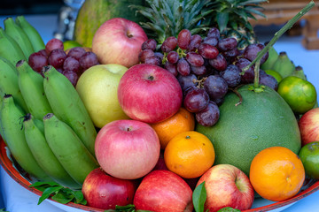 Assortment of fresh fruit banana, grapes, orange, apple, pineapple, tangerine and grapefruit on a tray. Closeup