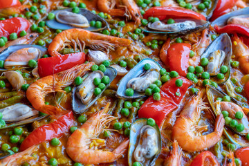 Spanish seafood paella in fry pan with mussels, shrimps and vegetables. Seafood paella background, closeup, traditional spanish rice dish