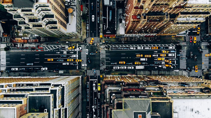 Luftaufnahme der Gebäudedächer der Innenstadt von New York. Vogelperspektive vom Helikopter auf die Infrastruktur der Stadtmetropole, Verkehrsautos, gelbe Taxis, die sich auf den Straßen der Stadt bewegen und die Alleen des Bezirks überqueren