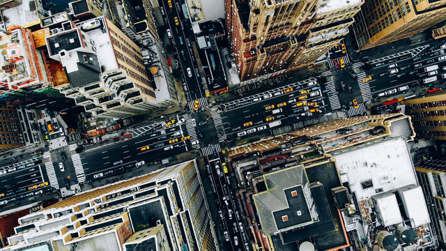 Aerial view of New York downtown building roofs. Bird's eye view from helicopter of cityscape metropolis infrastructure, traffic cars, yellow cabs moving on city streets and crossing district avenues