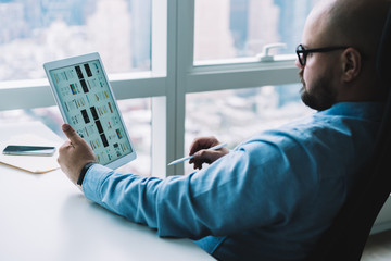 Businessman surfing tablet at desk