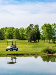 golf cart reflecting in large water hazard