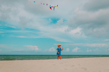 cute little girl flying a kite at sky on beach