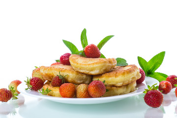 fried sweet pancakes with ripe strawberries in a plate