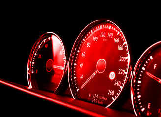 Close up shot of a red speedometer in a car. Car dashboard. Dashboard details with indication...