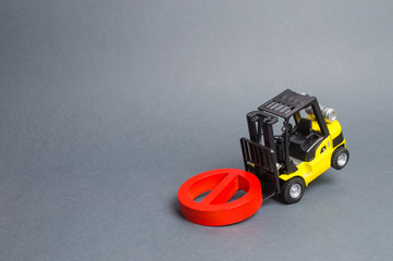 Fototapeta premium A yellow forklift truck cannot lift a red NO symbol. The concept of prohibition, sanctions and restrictions. Overcoming difficulties, bypassing difficulties, loopholes in the law. Embargo. bankrupt