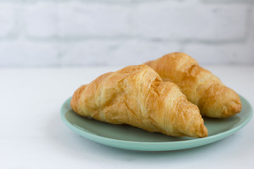 fresh delicious croissants on a plate on the table