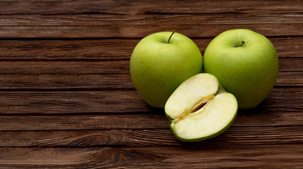 Green apples on dark brown wooden background. Summer fruits. Natural vitamins. Healthy food.