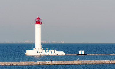 White lighthouse. The blue sea. Waves.