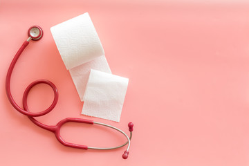 Disease of colon concept with toilet paper roll and stethoscope on pink background top view mock up