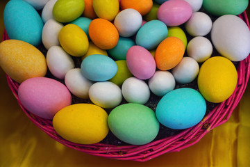 Fototapeta na wymiar Basket of colorful Easter eggs chocolate candies
