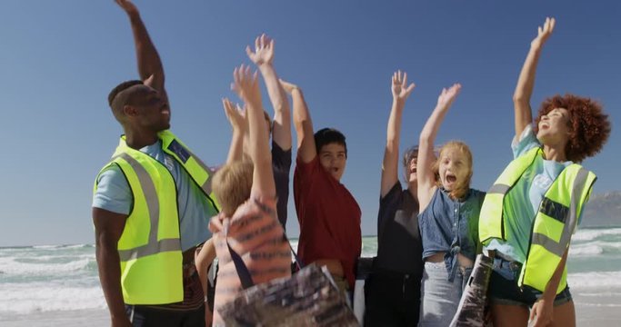 Volunteers forming hand stack on the beach 