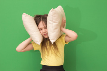 child covers the ears with pillows, the girl suffers from insomnia