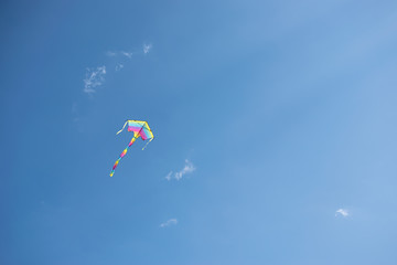 Rainbow kite flying in the blue sky. Tolerance and love concept. Copy space for your design.