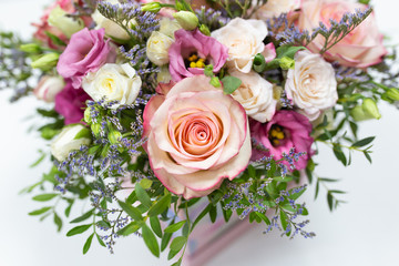delicate floral arrangement of roses and live decorations in a square cardboard box (primary color...