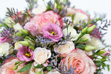 delicate floral arrangement of roses and live decorations in a square cardboard box (primary color - pink) on a light background