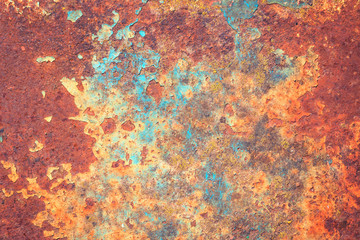 Bright rich colors of old grunge cracked blue weathered wall paint peeling off red rusted metal...