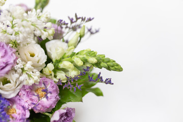 Exquisite bouquet of Roses, Eustoma, Veronica, Snapdragon and Lilac (white, lilac, green blue, lime, purple) in a small gift cardboard box on a light background