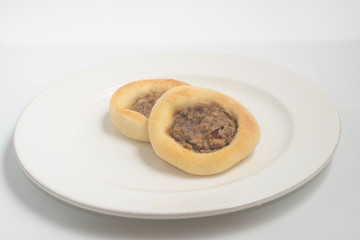 Arabic Meat sfiha over a wooden table.