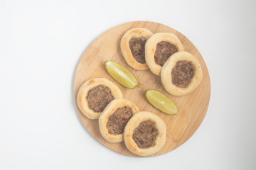 Arabic Meat sfiha over a wooden table.