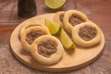 Arabic Meat sfiha over a wooden table.