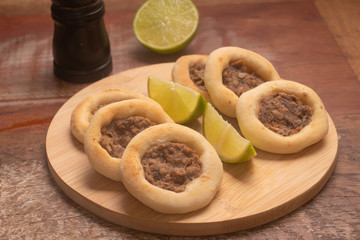Arabic Meat sfiha over a wooden table.