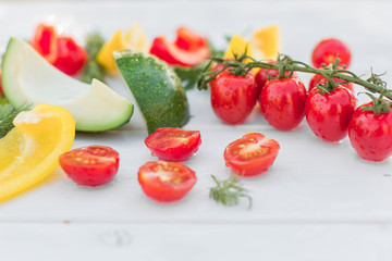 Fresh organic vegetables, cherry tomatoes, avocado, cucumbers, carrot, red and yellow pepper, green. Vegan food, healthy lifestyle concept