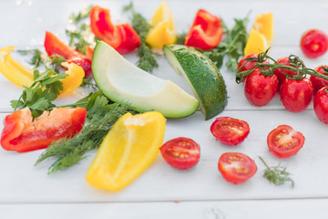 Fresh organic vegetables, cherry tomatoes, avocado, cucumbers, carrot, red and yellow pepper, green. Vegan food, healthy lifestyle concept