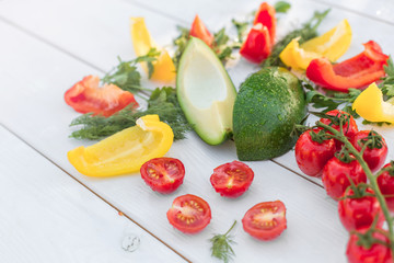 Fresh organic vegetables, cherry tomatoes, avocado, cucumbers, carrot, red and yellow pepper, green. Vegan food, healthy lifestyle concept