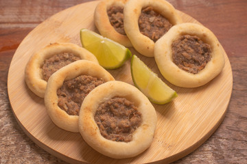 Arabic Meat sfiha over a wooden table.