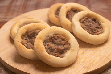 Arabic Meat sfiha over a wooden table.