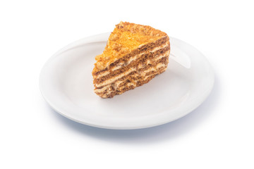 Slice of layered honey cake on a plate, isolated on white background