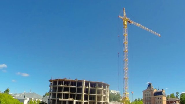 Construction work with a tower crane on the site with the workers. Time laps
