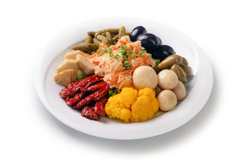 dried tomatoes, pickled cucumbers and cabbage, marinade assortment, salad, different pickles appetizer for a feast on a plate, isolated on white background