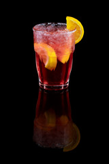 Red cocktail with orange slice, summer cool drink over black background