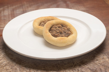Arabic Meat sfiha over a wooden table.