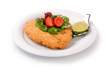Delicious steak in breadcrumbs Panko and fresh vegetable salad and lime on a plate, isolated on white background