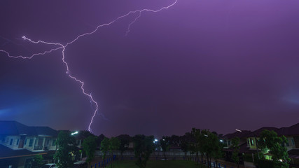 Lightning bolt during raining storm over home garden