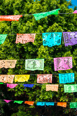 Tradicional decoración de papeles picados bajo un cielo azul.