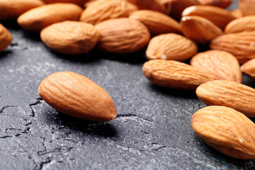 Almonds on a black concrete background close-up. Top view. Place for text.