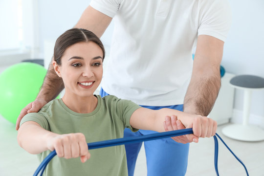 Professional physiotherapist working with female patient in rehabilitation center