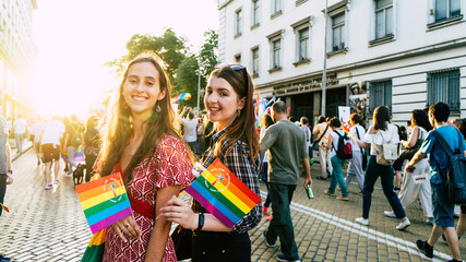Sofia / Bulgaria - 10 June 2019: smiling Girls in LGBT parade with rainbow flag in the street. Gay...