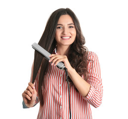 Young woman using hair iron on white background