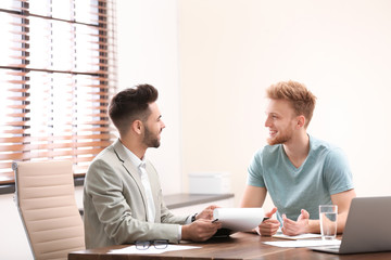 Insurance agent consulting young man in office