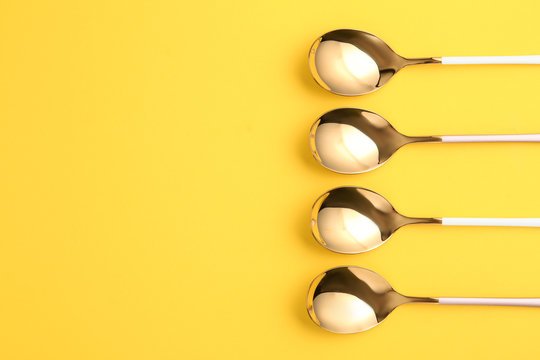 Flat lay composition with clean tablespoons and space for text on color background
