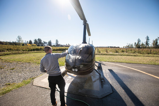 Pilot maintains and washes his helicopter after a day of flying,