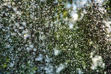 abstract background water drops fountain splashes glare from summer sun