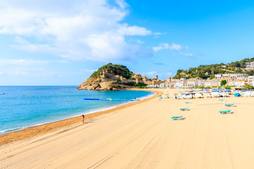 Fototapeta na wymiar Blue azure sea and sandy beach view in Tossa de Mar, Costa Brava, Spain
