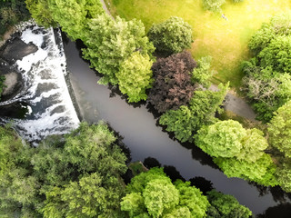Aerial view of a nice green forest cut by a river with a beautiful waterfall